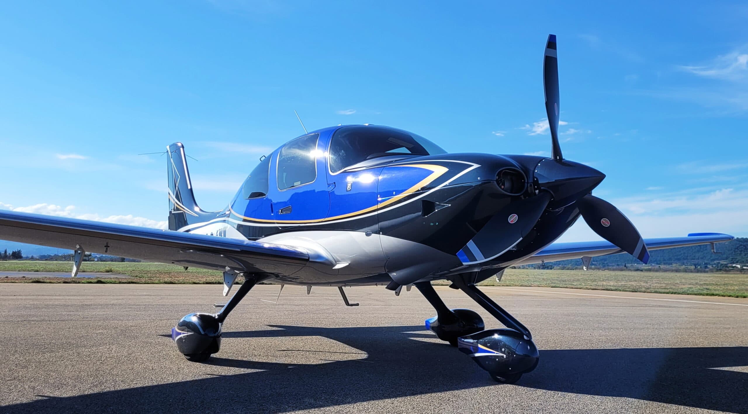 A Cirrus SR22 on the ramp beneath a clear sky
